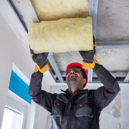 Male,Worker,In,Uniform,With,Helmet,Installing,Glass,Wool,For